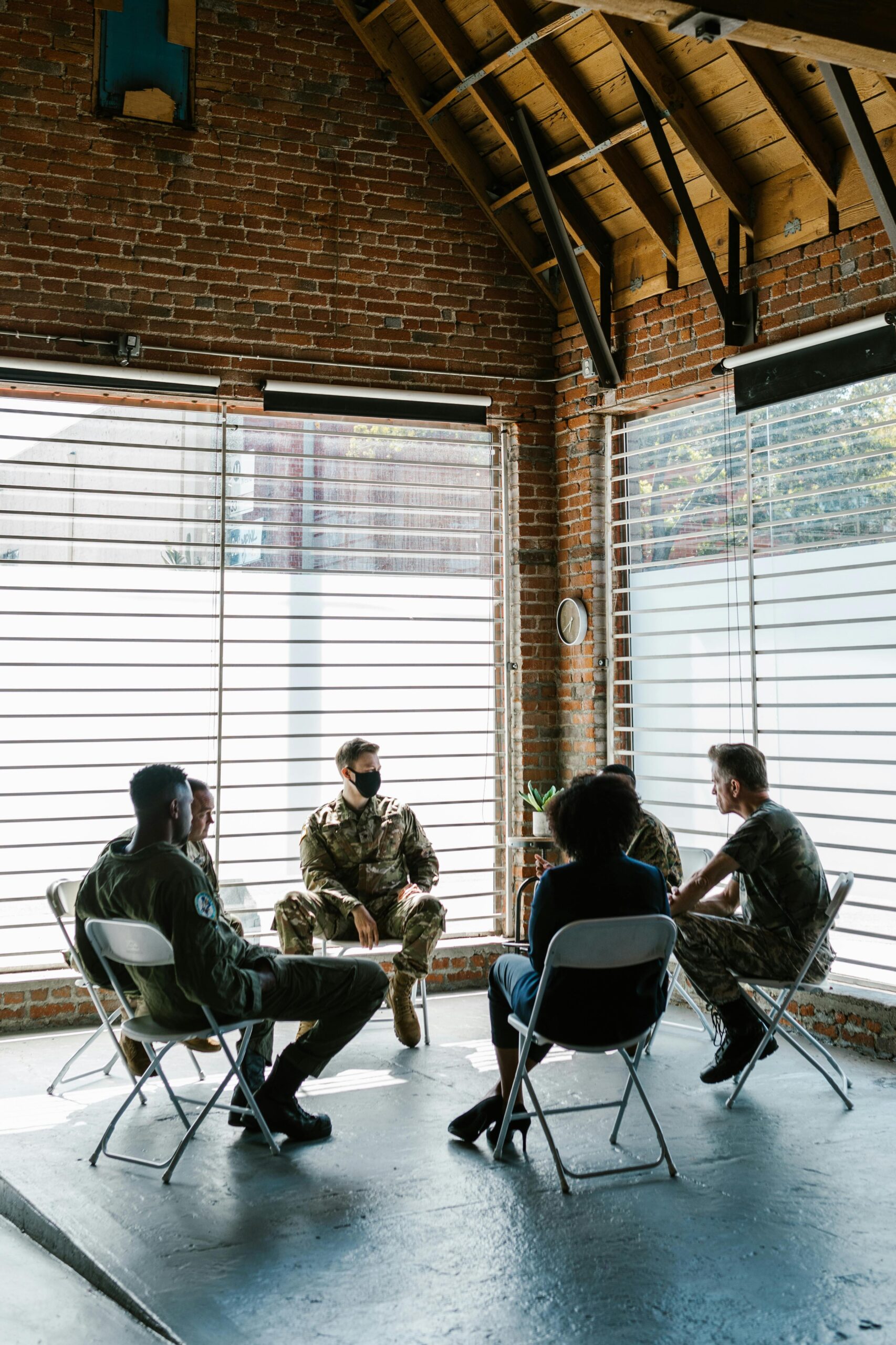 Soldiers in a group therapy session discussing mental health indoors.