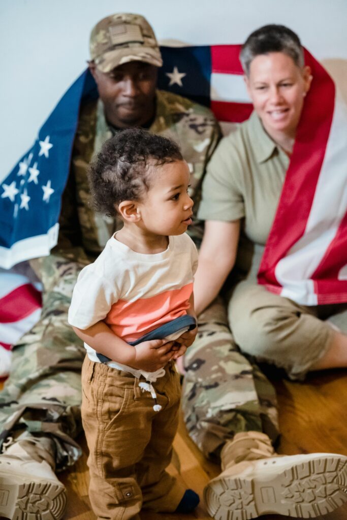 Family enjoying a moment with an American flag, showing unity and military pride.